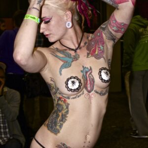 Topless woman showing off many tattoos